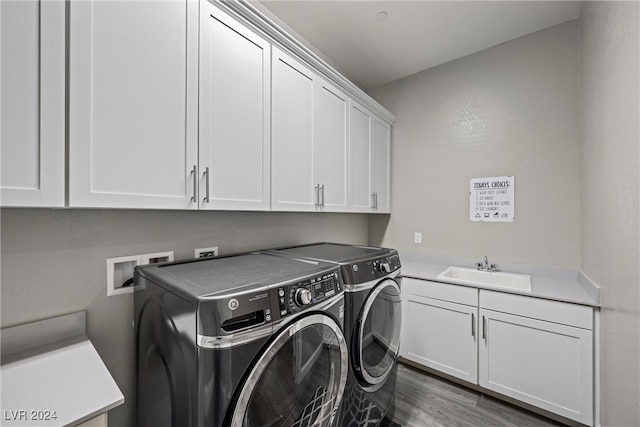 laundry room with cabinets, dark hardwood / wood-style floors, sink, and washer and clothes dryer