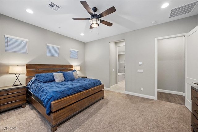 carpeted bedroom with ensuite bathroom and ceiling fan