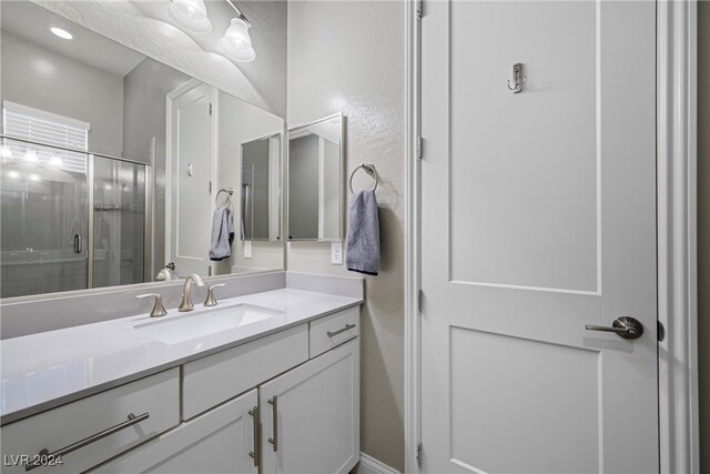 bathroom featuring walk in shower and vanity