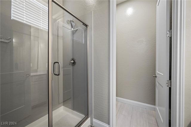 bathroom featuring a shower with shower door