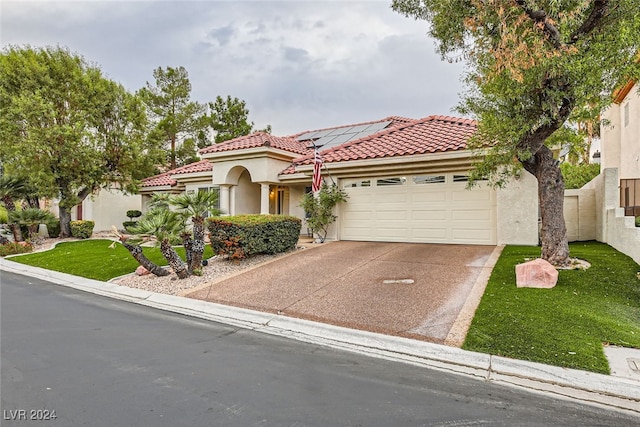 mediterranean / spanish-style house with a garage and a front lawn