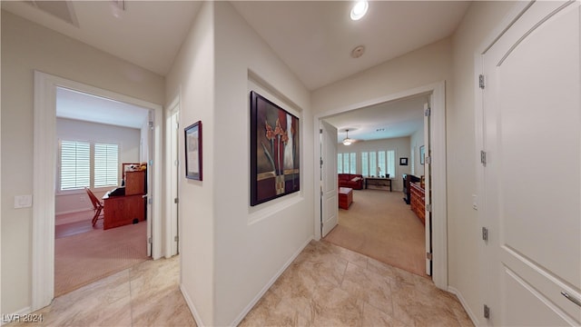 corridor with light colored carpet and lofted ceiling