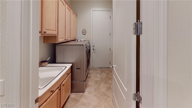 washroom with cabinets, sink, and washer and dryer