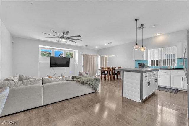 living room with light hardwood / wood-style floors and ceiling fan