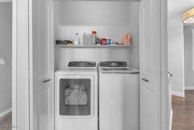 laundry area with wood-type flooring and washer and clothes dryer