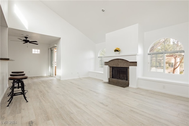 unfurnished living room with high vaulted ceiling, light hardwood / wood-style floors, and ceiling fan