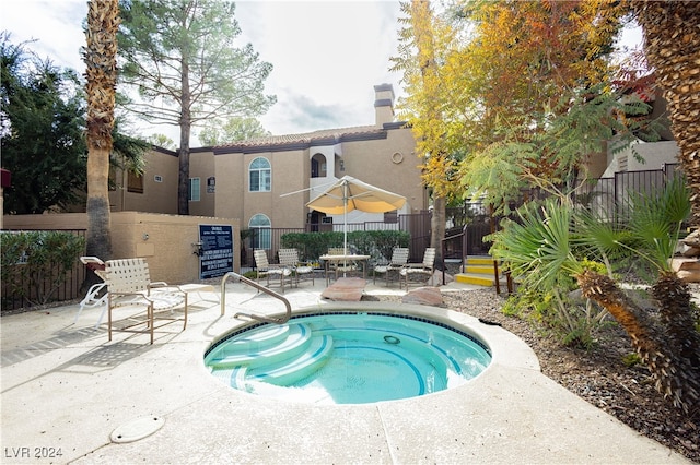 view of pool with a hot tub and a patio area