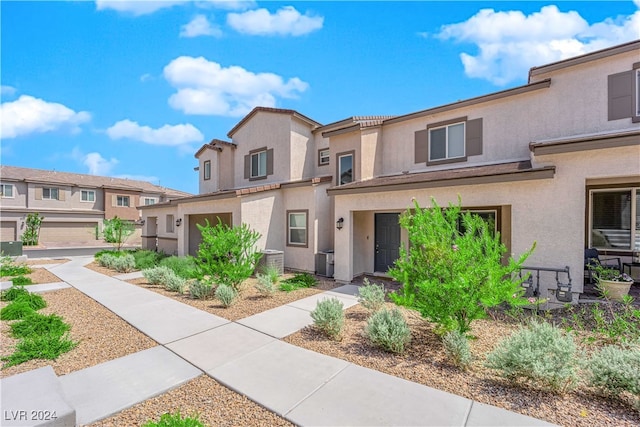 townhome / multi-family property featuring a garage and central AC unit