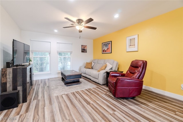 living room with light hardwood / wood-style flooring and ceiling fan