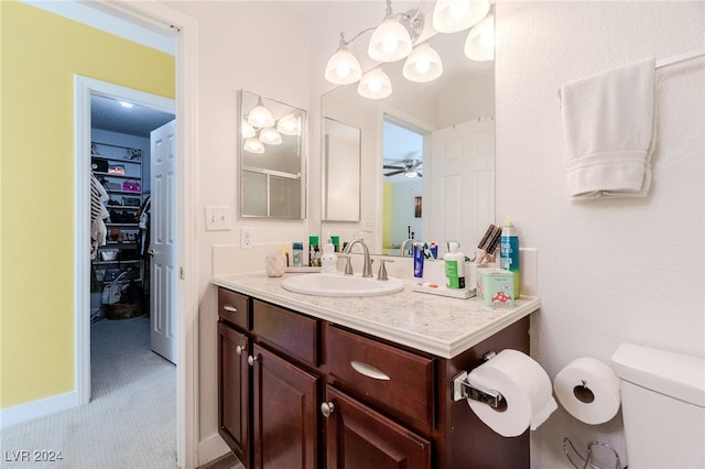 bathroom with vanity, ceiling fan, and toilet