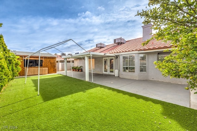 rear view of property featuring french doors, a patio, and a yard