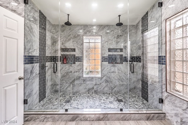 bathroom featuring a wealth of natural light and a shower with door