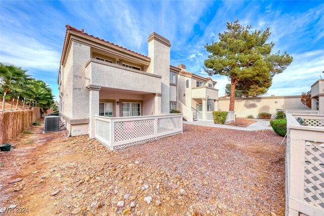 back of property with a balcony and cooling unit