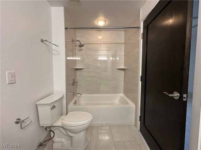 bathroom featuring toilet and tiled shower / bath