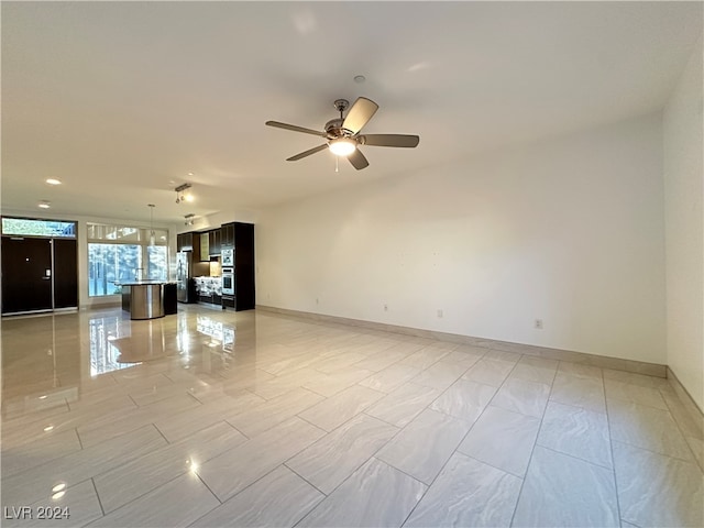 unfurnished living room featuring ceiling fan