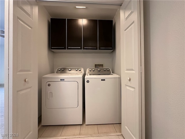 washroom featuring washing machine and dryer and cabinets