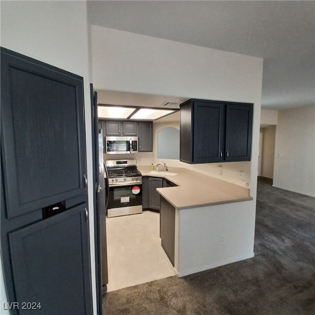 kitchen featuring kitchen peninsula, sink, appliances with stainless steel finishes, and carpet floors