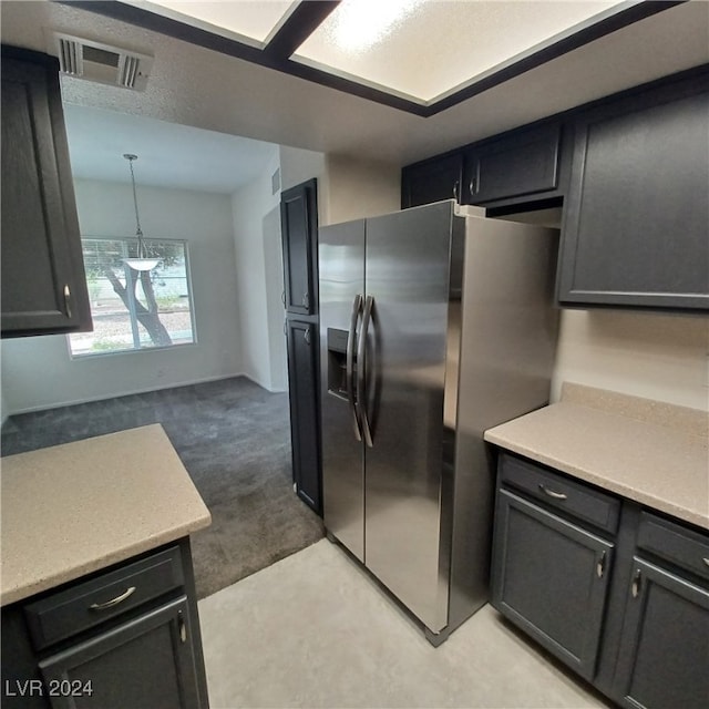 kitchen featuring stainless steel fridge, light carpet, and pendant lighting