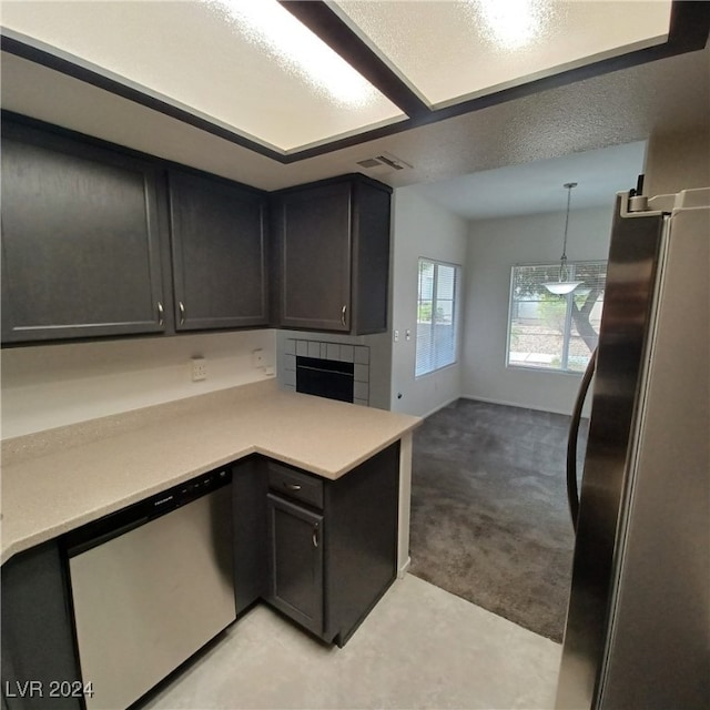 kitchen with stainless steel appliances, kitchen peninsula, a textured ceiling, light carpet, and pendant lighting