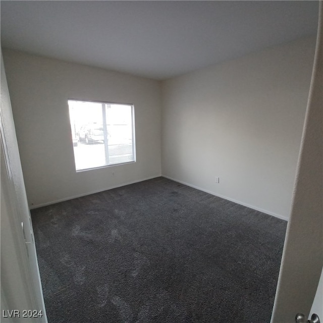 empty room with dark colored carpet