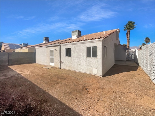 rear view of house with central air condition unit and a patio area