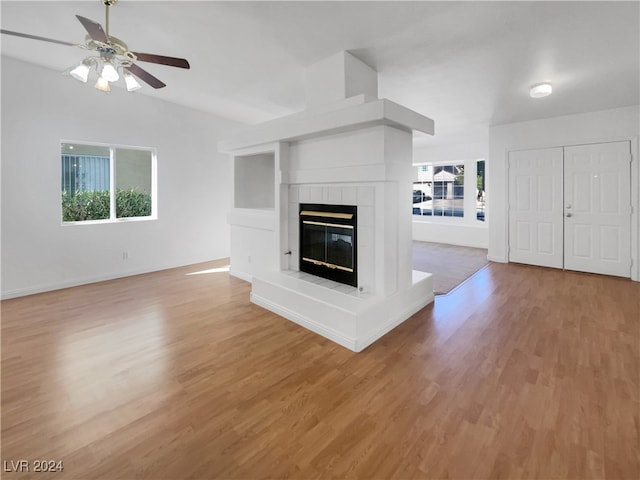 unfurnished living room with a fireplace, a wealth of natural light, and light hardwood / wood-style flooring