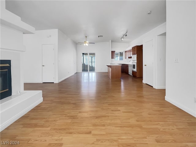 unfurnished living room featuring light hardwood / wood-style flooring, rail lighting, and ceiling fan