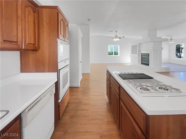 kitchen with white appliances, ceiling fan, light wood-type flooring, and vaulted ceiling