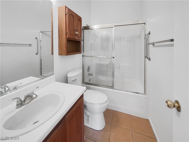 full bathroom featuring tile patterned flooring, vanity, toilet, and bath / shower combo with glass door