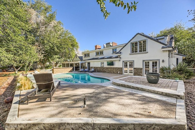 view of swimming pool with french doors and a patio area