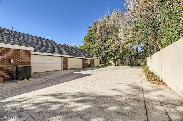 view of home's exterior with central AC and a garage