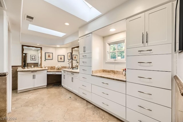 bathroom featuring a skylight and vanity