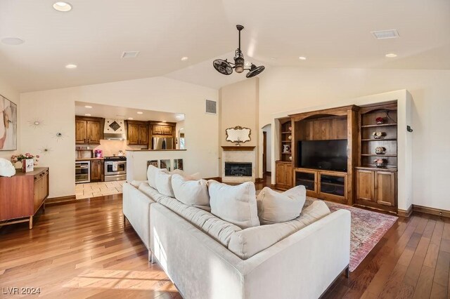 living room featuring lofted ceiling, hardwood / wood-style flooring, and wine cooler