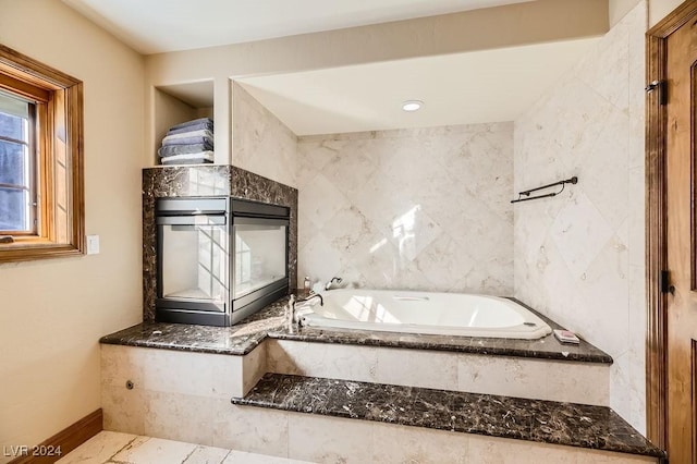 bathroom with a relaxing tiled tub