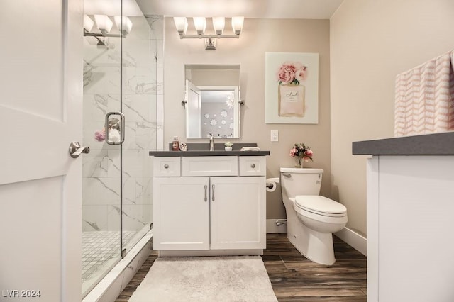 bathroom featuring vanity, walk in shower, toilet, and hardwood / wood-style floors