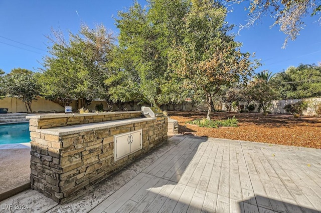 wooden deck with a fenced in pool