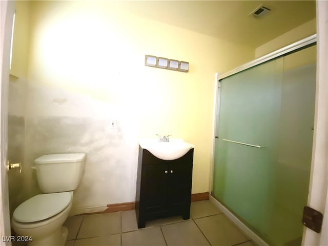 bathroom with tile patterned flooring, vanity, toilet, and a shower with door