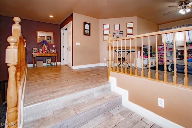 staircase with hardwood / wood-style flooring and ceiling fan