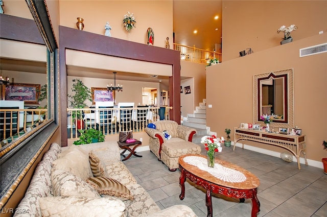 living room with a high ceiling, a chandelier, and tile patterned flooring