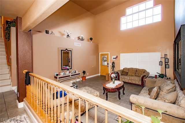 living room featuring tile patterned flooring and a high ceiling