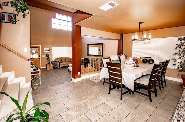 dining space featuring light tile patterned floors and a notable chandelier