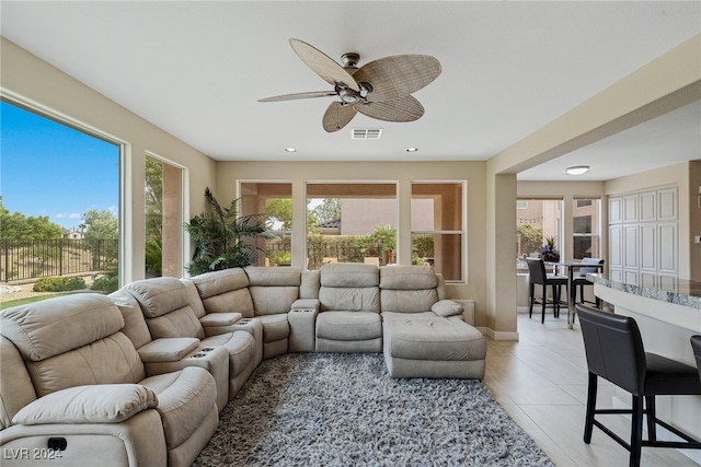 tiled living room with ceiling fan and a healthy amount of sunlight