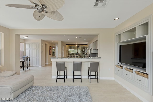 living room featuring ceiling fan and light tile patterned floors