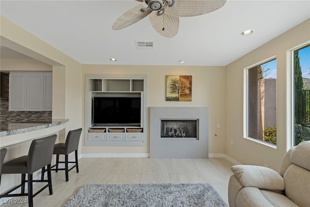 living room with a wealth of natural light, ceiling fan, and light tile patterned floors