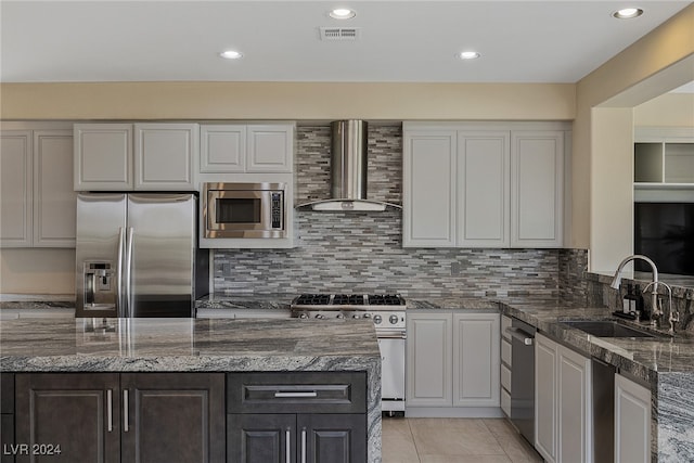 kitchen with white cabinets, appliances with stainless steel finishes, sink, and wall chimney range hood