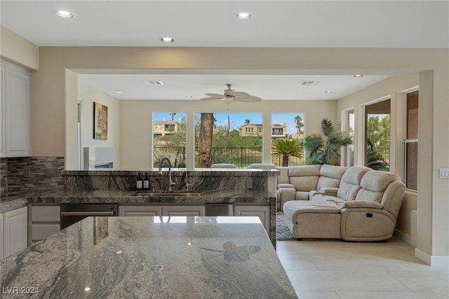 living room with sink, light tile patterned floors, and ceiling fan