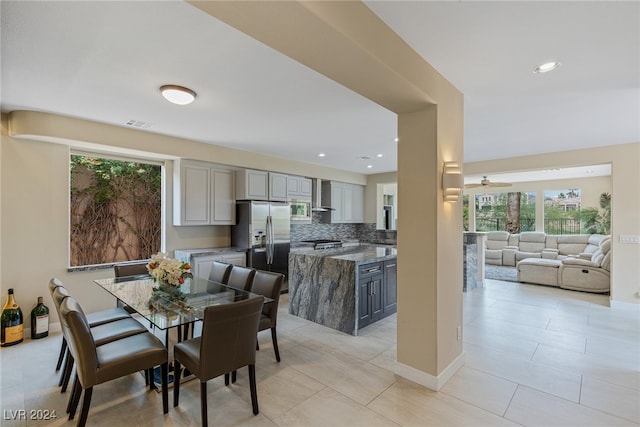 tiled dining space with ceiling fan