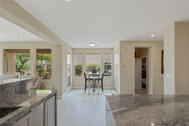 kitchen featuring light tile patterned flooring and dark stone countertops