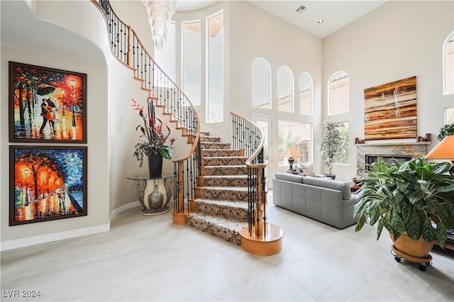 stairway featuring a towering ceiling and plenty of natural light