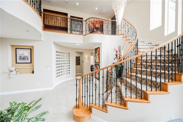 stairs featuring an inviting chandelier and a towering ceiling